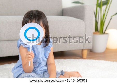 Girl holding a correct answer panel in her hand