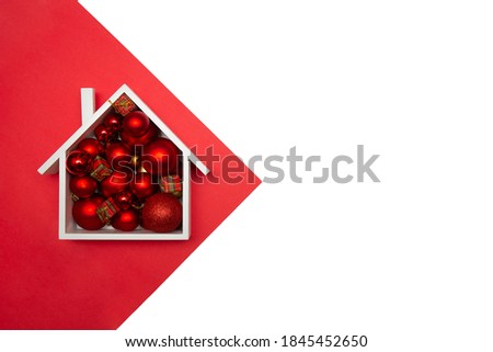 Christmas background of a festive house with Christmas tree baubles. Christmas card design with festive decoration on white background. Christmas and New Year decorations with copy space.