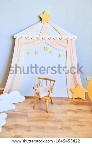 Stylish children's room with a small chair and stars. The concept of room for the baby.