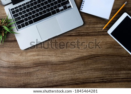 Office equipment, laptops, tablets, pens, smartphones, notebooks on a wooden table background Top view from the top