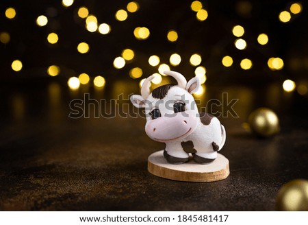 christmas background. Xmas bull, symbol chinese happy new year 2021 against the background of christmas lights. Copy space. dark background. soft focus