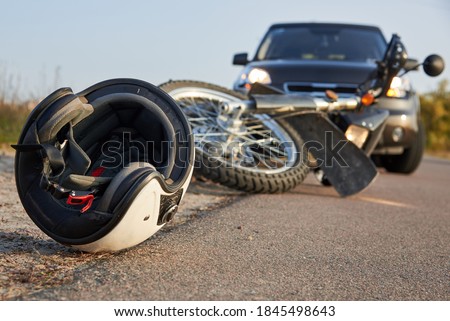 Photo of car, helmet and motorcycle on road, the concept of road accidents. Royalty-Free Stock Photo #1845498643