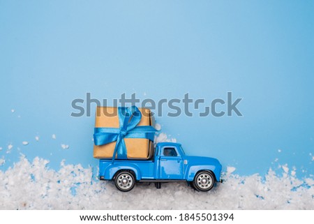 gift box with blue ribbon on the car. flat lay with snow top view.