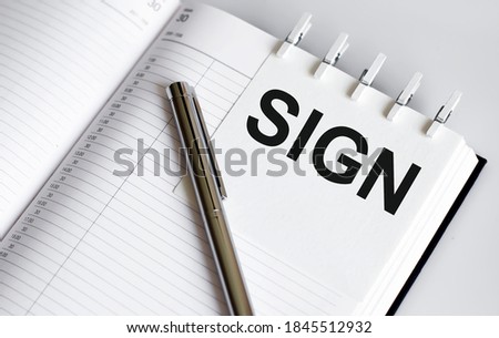 text SIGN on short note texture background with pen