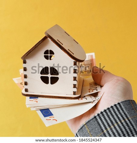 house model on sale with money on yellow background, house for sale concept