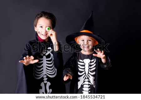 Child, dressed for Halloween, playing at home, isolated image on black background