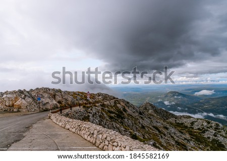 Biokovo, Croatia. Mountain landscape with low clouds. Warning road sign with exclamation mark and 30 mph speed limit sign
