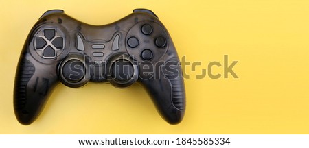 Joystick gaming controller isolated on yellow background.