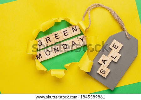 Green Monday text on  a yellow paper background with a hole. Design for promotion of winter end of year sale.