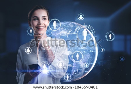 Portrait of smiling young businesswoman using smartphone in blurry office with double exposure of HR interface and planet hologram. Toned image. Elements of this image furnished by NASA