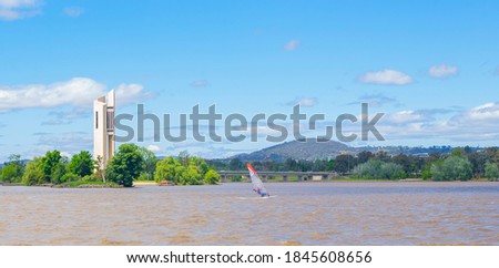 View of a windsurfer on Lake Burley Griffin with the National Carillon on Aspen Island in the background in Canberra, the capital city of Australia Royalty-Free Stock Photo #1845608656