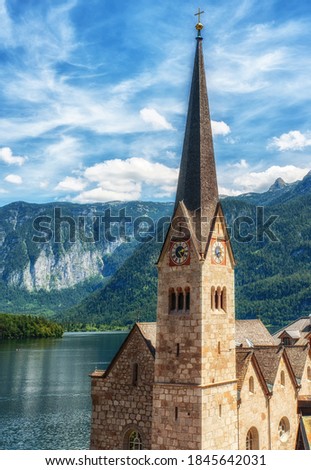 Evangelical church with tall spire on the clock tower is the architectural symbol and one of the most known landmarks of Hallstatt, situated on the bank of Hallstattersee lake, Salzkammergut, Austria