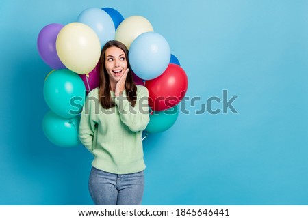 Photo portrait of surprised impressed girl hiding colorful balloons dreaming about wish smiling isolated on vivid blue color background
