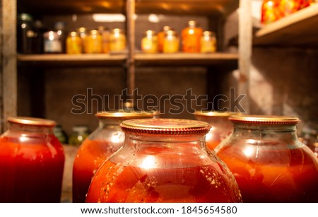 Photo of canned vegetables, in an old cellar with dim lighting, and with wooden shelves