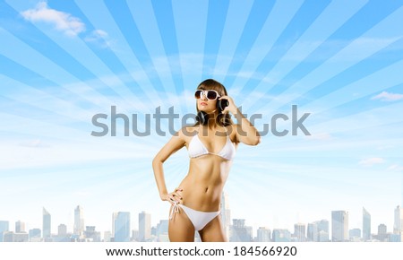 Young attractive girl in white bikini wearing headphones