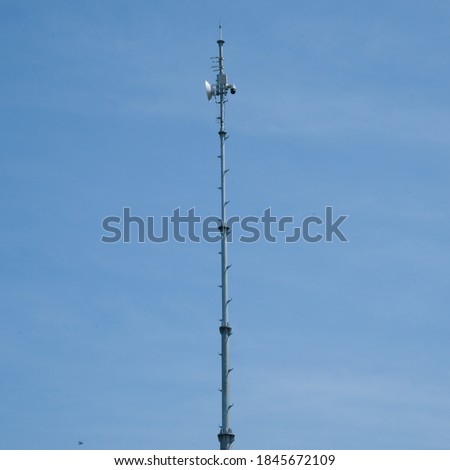 An internet and CCTV tower made of metal at Mount Merapi observation post in Klangon, Central Java, Indonesia. photogrpahed at long range with clear blue sky as background.