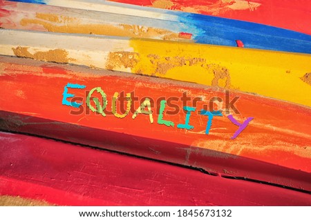 Equality word on colorful side view of kayak boat with sand. Social issue concept and LGBT idea