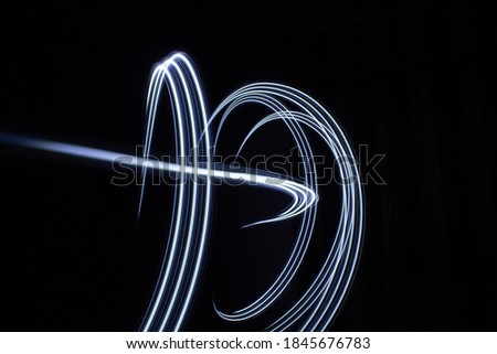 blue parallel lines pattern against a black background. Light painting photography.