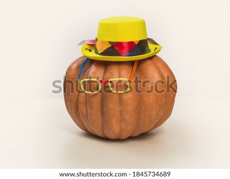 Pumpkin in a carnival hat and glasses.