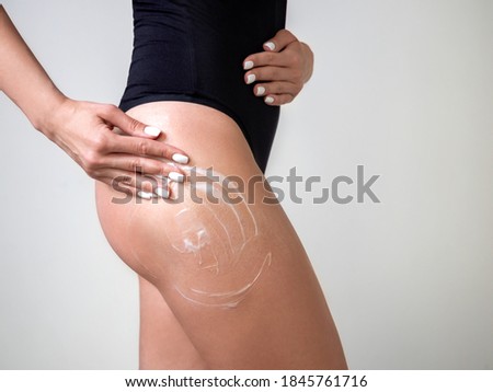 the girl smears the body with cream. body care