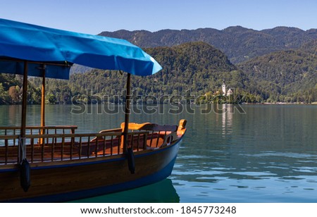 A picture of one of Lake Bled's gondolas, named "pletna", overlooking the Lake Bled Island.