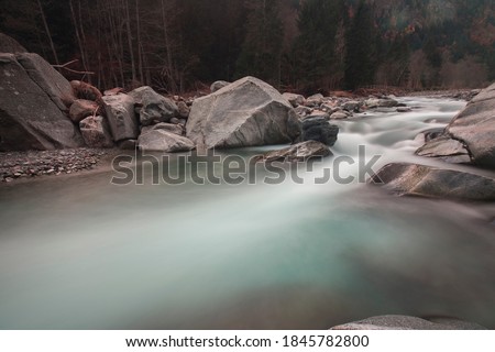 Long exposition shot of a river with silk effect on the water, while the rocks and background are sharp in focus. No people are visible.