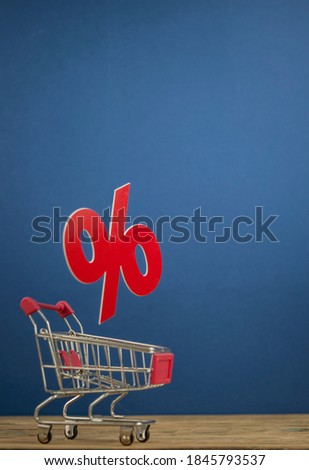 Sale percentages falling into shopping cart on dark blue background