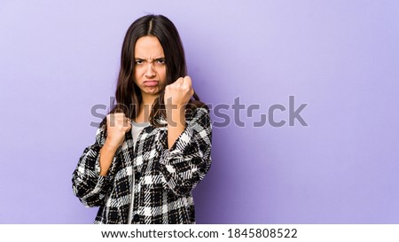 Young mixed race hispanic woman isolated showing fist to camera, aggressive facial expression.