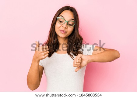 Young mixed race hispanic woman isolated showing thumbs up and thumbs down, difficult choose concept
