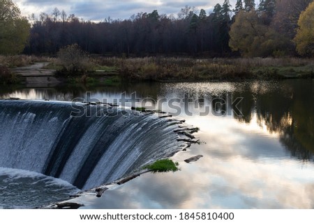waterfall in autumn, sky reflection in water