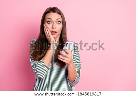 Photo of surprised funny young lady stand read news hand on cheek wear pullover isolated on pastel pink color background