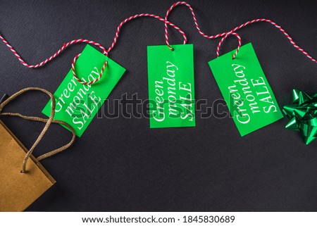 Christmas Clearance and Sale Concept. Black Friday, Green Monday (Cyber Monday) Sale. With Discount Price Tags, Black gadgets and accessories, Shopping Bag. Flat lay top view, black matte background