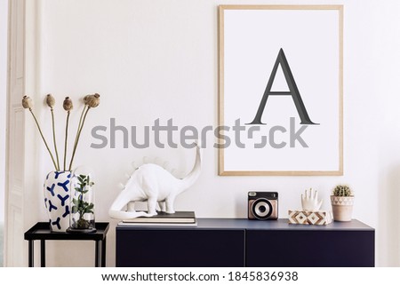 Scandinavian living room interior with mock up photo frame, navy blue commode, book, dinosaur lamp, decoration and elegant accessories. Stylish home decor. Template.