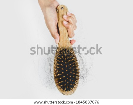 Woman losing hair on hairbrush in hand, Hair loss, hair fall everyday serious problem, on white background.Solutions for hair loss.