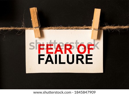 a sheet on a black background with text FEAR OF FAILURE. business concept