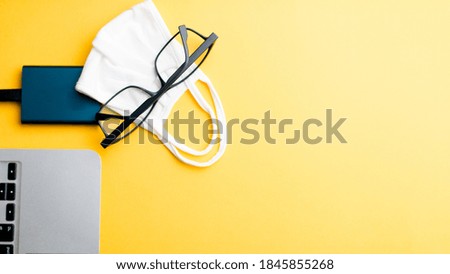 computer and work tools on yellow background, work from home concept