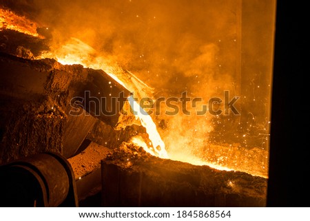 Tank pours liquid metal in the molds at the steel mill Royalty-Free Stock Photo #1845868564