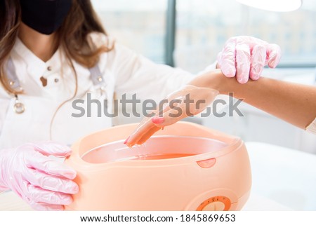 process paraffin treatment of female hands in a beauty salon Royalty-Free Stock Photo #1845869653