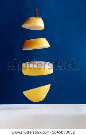 floating pieces of yellow pear against blue background, creative picture
