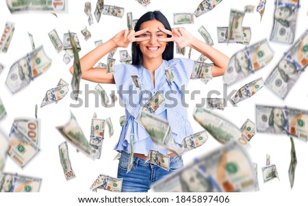 Young beautiful latin girl wearing casual clothes doing peace symbol with fingers over face, smiling cheerful showing victory