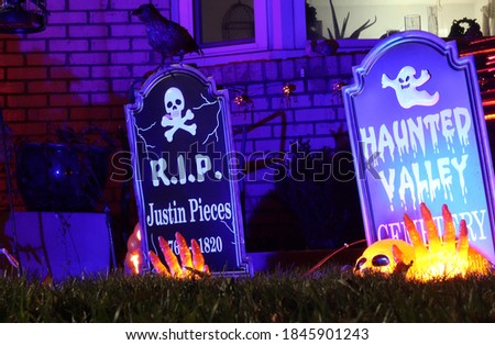Halloween decorations in a yard in front of a house.