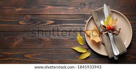 Happy Thanksgiving Day, banner design. Festive table setting with autumn leaves and space for text on wooden background, flat lay