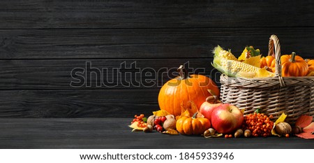 Happy Thanksgiving Day, banner design. Composition with vegetables, fruits and autumn leaves on black wooden table, space for text 