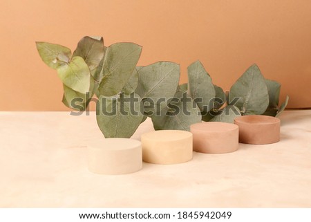 Empty geometrical podiums for displaying products.Fresh eucalyptus branch on the background.Beautiful earth colors.Concept of the natural cosmetic and health care.Good for placing your items.