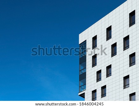 Urban abstract image. Part of the facade of a modern building with copy space on a blue sky background