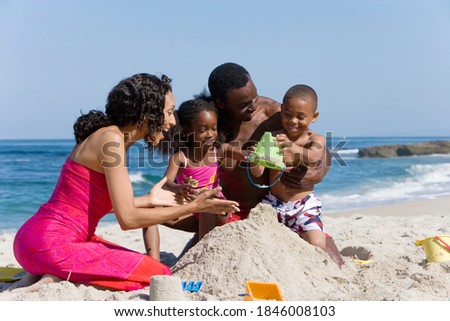 A happy African American family making sandcastle together on a beach. Royalty-Free Stock Photo #1846008103
