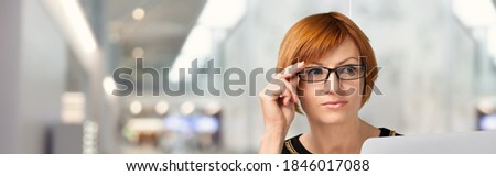 Young student girl wear glasses sit indoors look at pc screen study on-line
