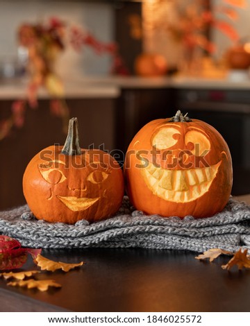 Two funny Halloween pumpkins on a table, indoors