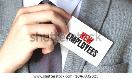 businessman holding a card with text NEW EMPLOYEES