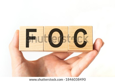 Hand holds wooden cubes with letters foc. Business concept image.